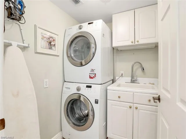 Laundry room with cabinet space and stacked washer / dryer