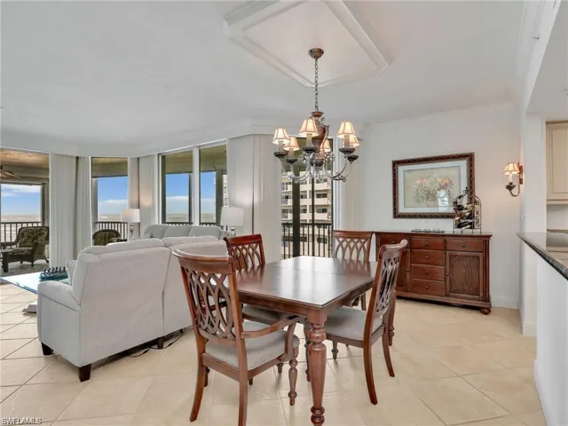 Dining space featuring light tile patterned floors, ornamental molding, and a chandelier