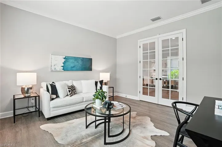Living room featuring french doors, ornamental molding, and wood finished floors