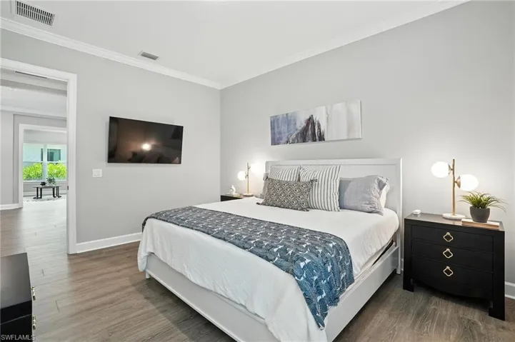 Bedroom featuring crown molding and wood finished floors