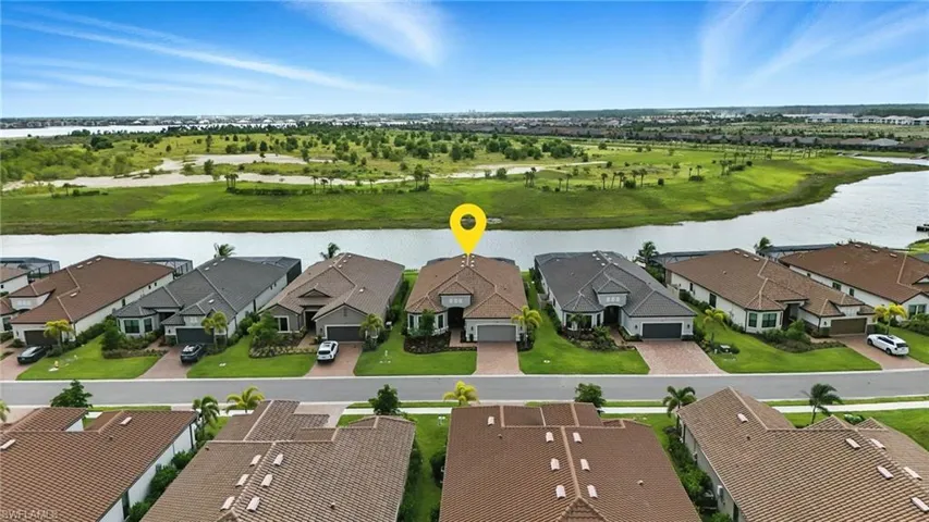 Aerial perspective of suburban area featuring a nearby body of water