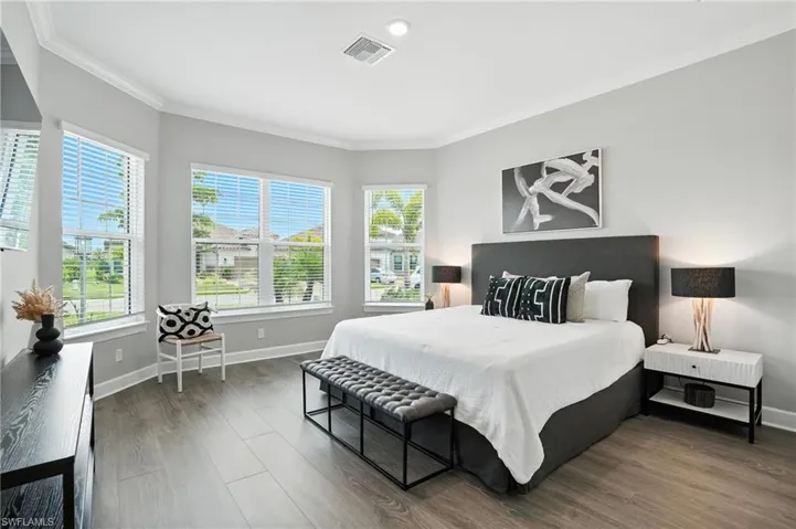 Bedroom with crown molding and wood finished floors