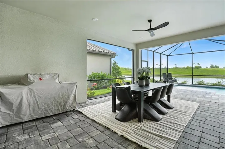 Sunroom / solarium with ceiling fan, a water view, and outdoor dining area