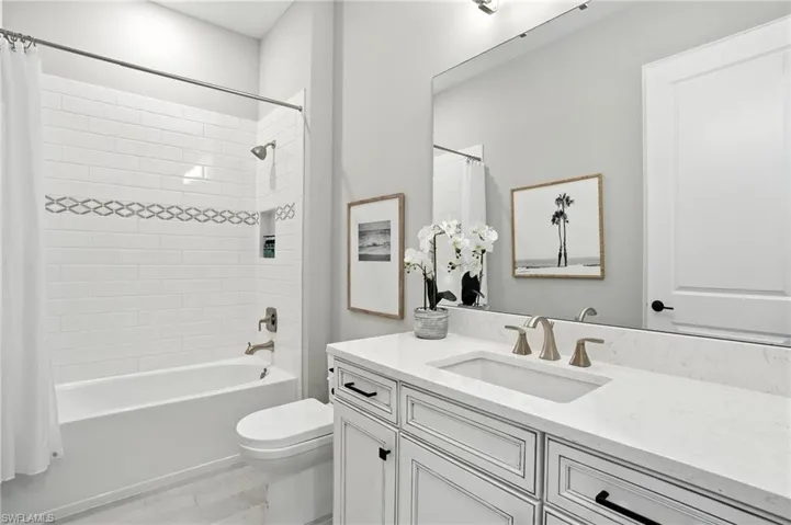 Full bath featuring vanity, shower / tub combo, and wood finished floors