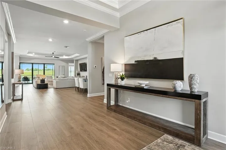 Living area featuring ornamental molding, wood finished floors, a ceiling fan, and recessed lighting