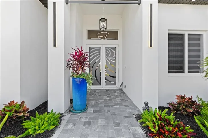 Property entrance with stucco siding and french doors