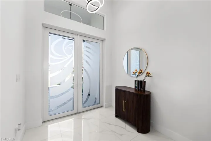 Entryway featuring french doors and light marble finish flooring