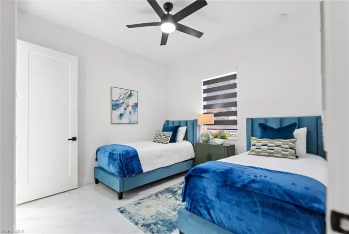 Bedroom featuring a ceiling fan and marble finish floors