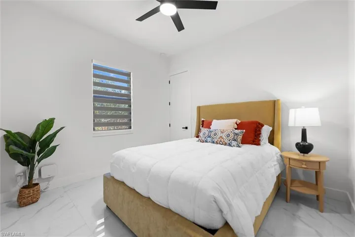 Bedroom featuring ceiling fan and baseboards
