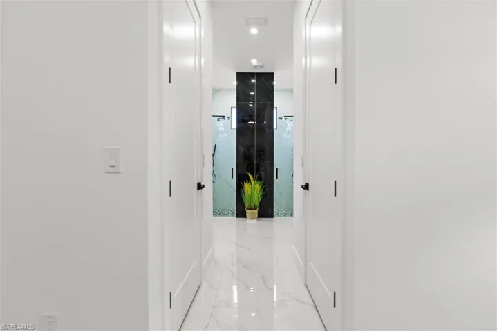 Corridor featuring light marble finish flooring and recessed lighting