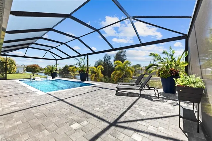 Outdoor pool featuring a sunroom, a lanai, and a patio area