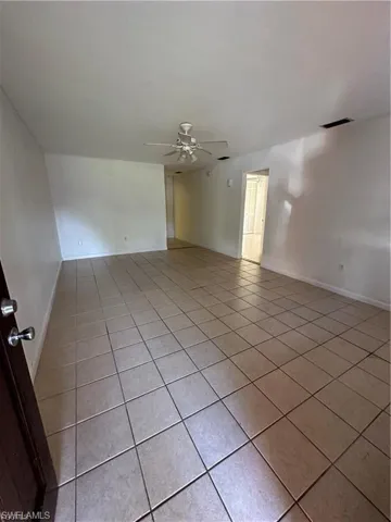 Unfurnished room with ceiling fan and light tile patterned flooring