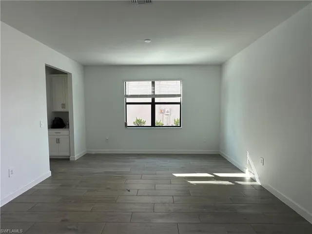Empty room with dark hardwood / wood-style floors