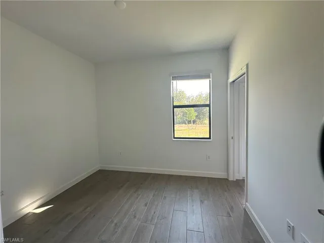 Empty room with hardwood / wood-style flooring