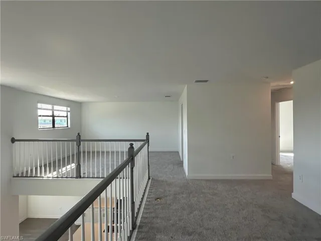Hallway featuring dark carpet