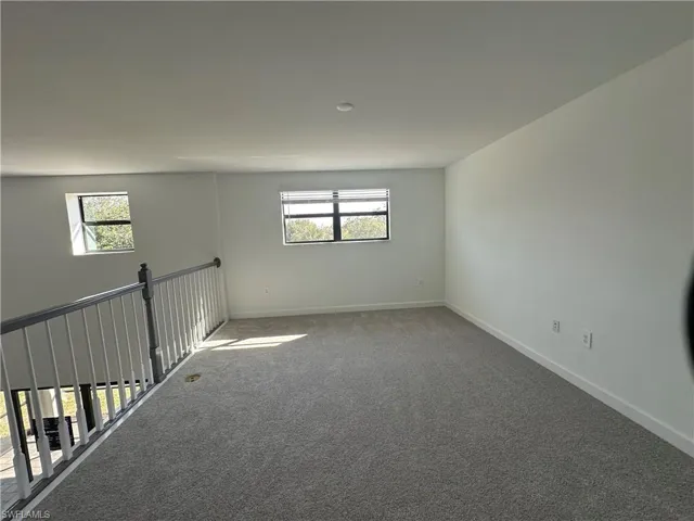 Carpeted empty room featuring a wealth of natural light