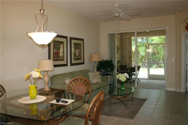 Tiled flooring throughout, ceiling fan, and sliding glass door leading to a screened lanai