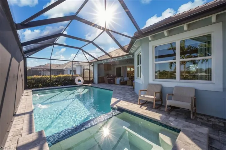 Combined pool / hot tub with a patio, a sunroom, and a lanai
