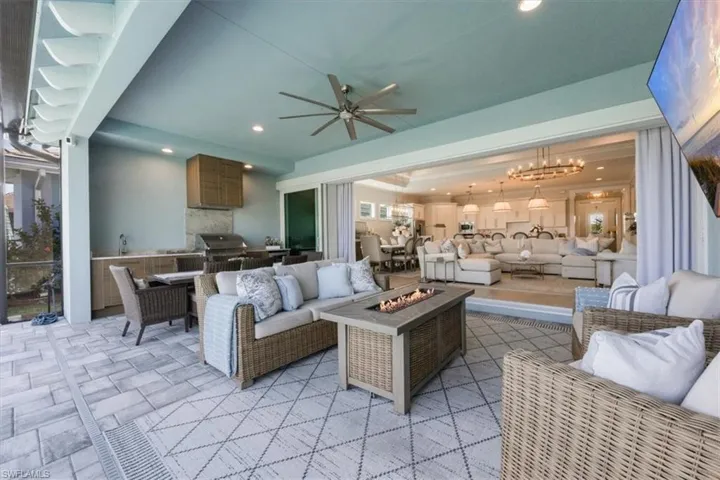 Living room featuring hanging lights, ceiling fan, and stone tile flooring