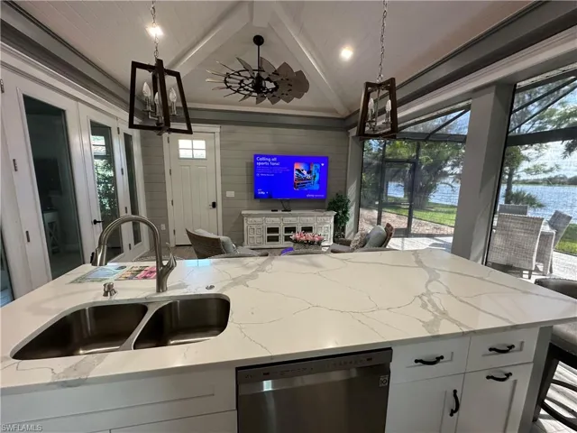 Kitchen with dishwasher, lofted ceiling with beams, a healthy amount of sunlight, and white cabinetry