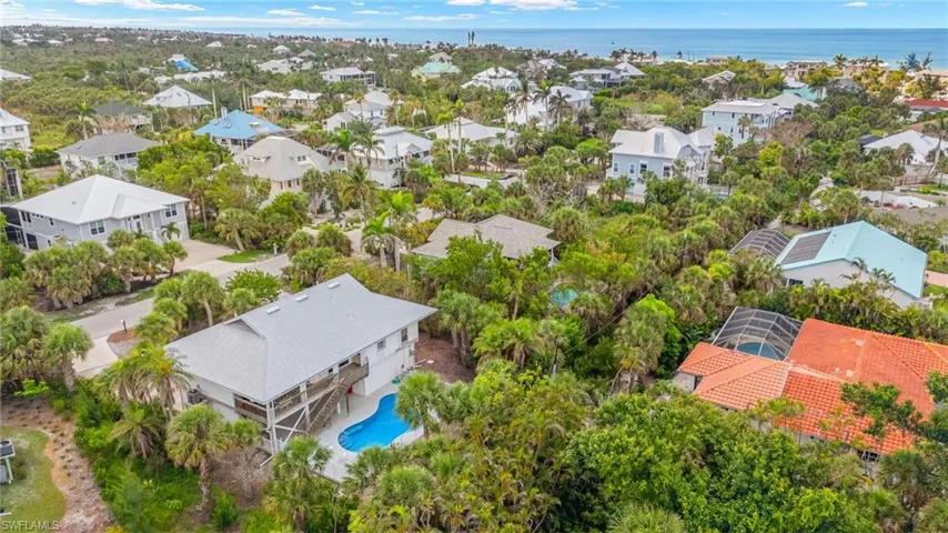 Aerial perspective of suburban area featuring a nearby body of water and a pool area