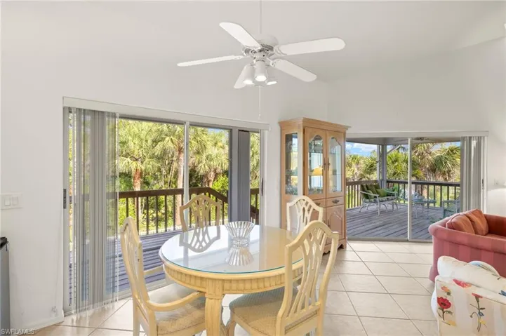 Dining room featuring light tile patterned flooring, plenty of natural light, and a ceiling fan