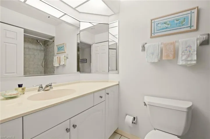 Full bath with vanity, toilet, and tiled shower