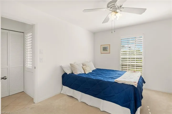 Bedroom featuring light carpet, baseboards, and ceiling fan