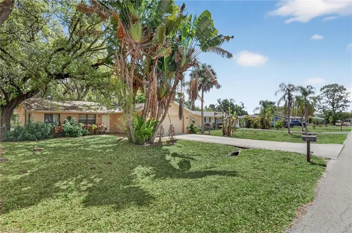 View of front facade with concrete driveway, a front yard, and an attached garage