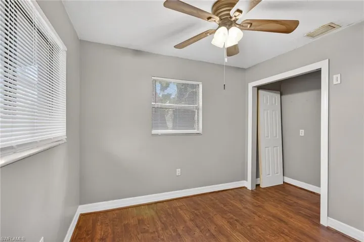 Unfurnished bedroom featuring ceiling fan and dark wood finished floors