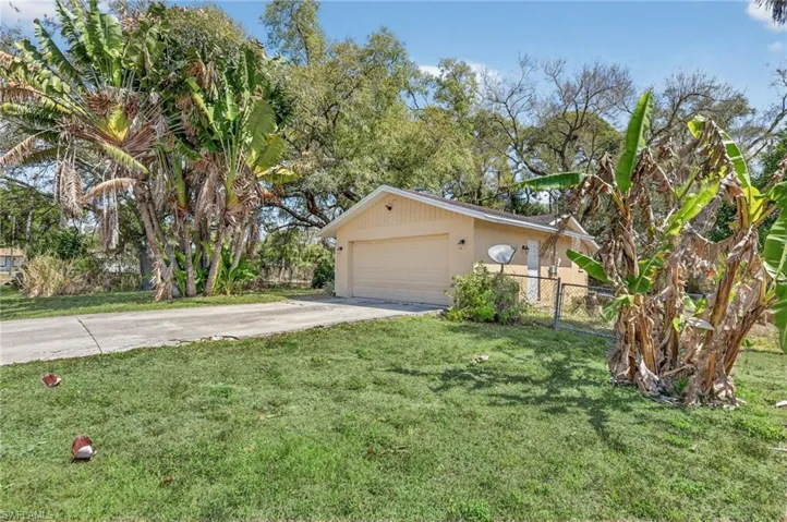 View of front of home with driveway, stucco siding, and a gate
