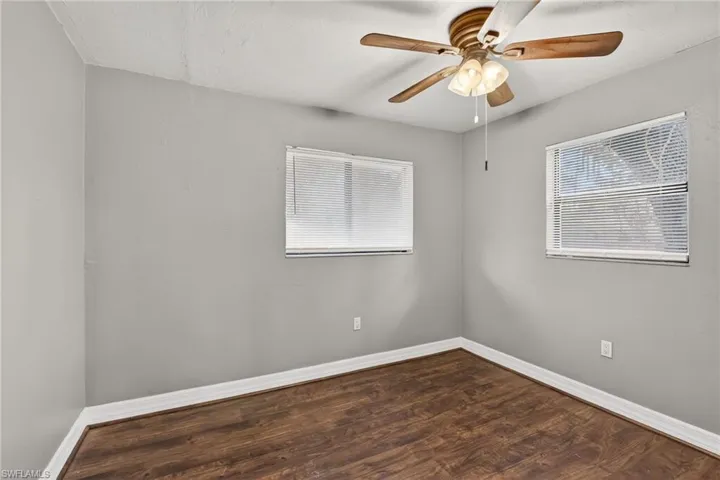 Spare room featuring dark wood-style flooring and a ceiling fan