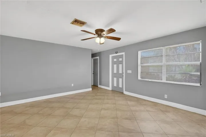 Spare room featuring ceiling fan and baseboards