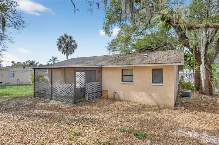 Back of house with stucco siding and a sunroom