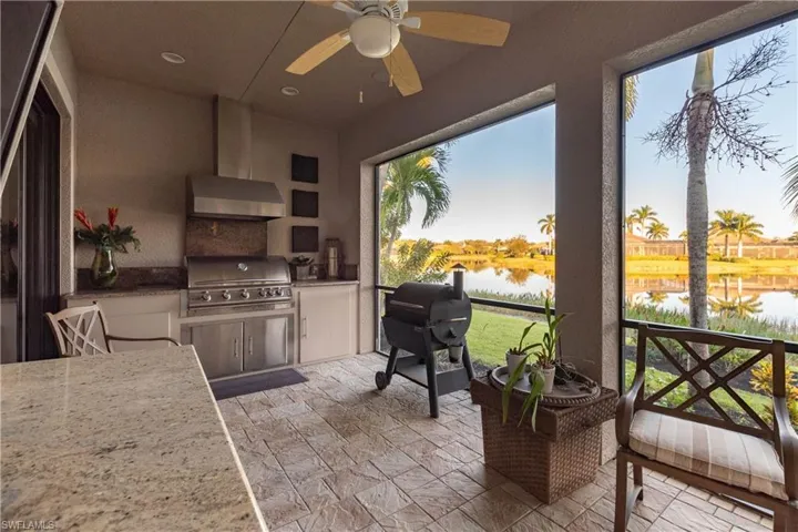 Lanai featuring a water view, ceiling fan and grilling station