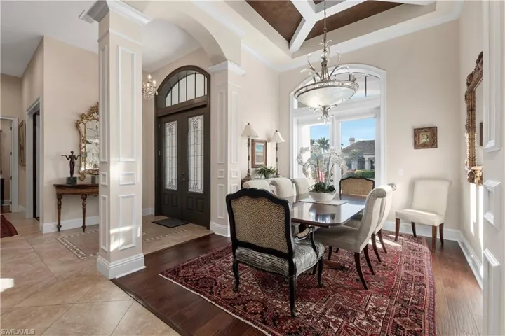 Dining area featuring crown molding,  wood-style flooring and a towering ceiling.