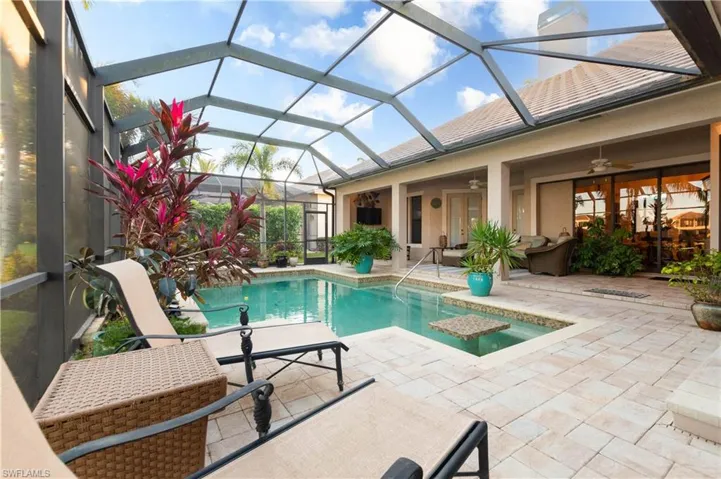 View of pool featuring ceiling fan, a patio, and glass enclosure