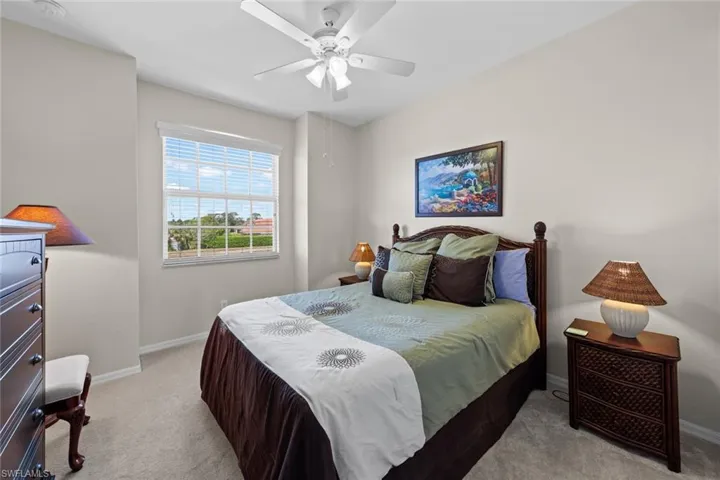 Bedroom with a ceiling fan, baseboards, and carpet floors