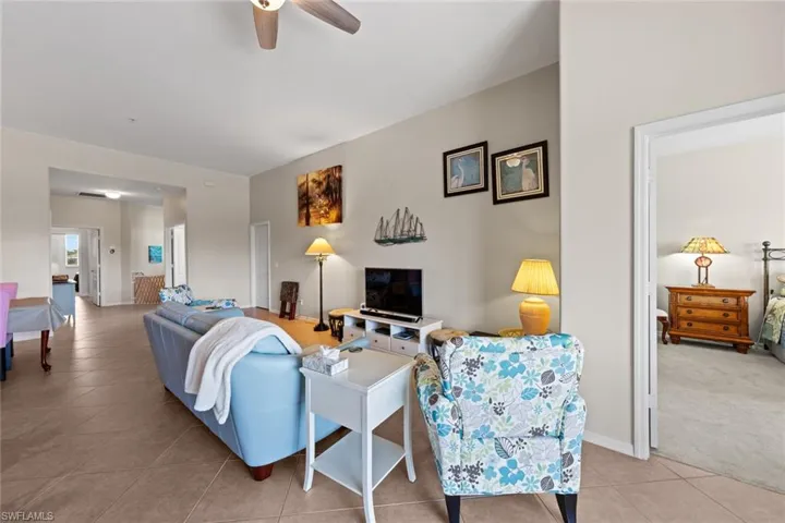 Living area featuring baseboards, a ceiling fan, and light tile patterned floors
