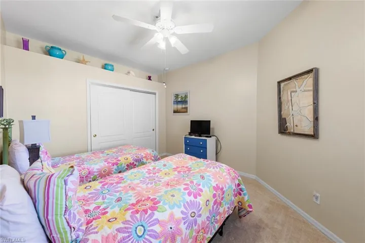 Bedroom with a ceiling fan, baseboards, carpet floors, and a closet
