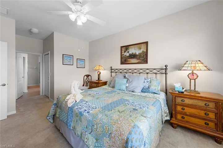 Bedroom featuring visible vents, a ceiling fan, light carpet, a closet, and baseboards
