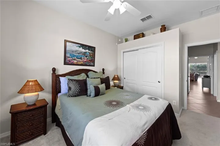 Bedroom featuring a closet, visible vents, baseboards, and light carpet