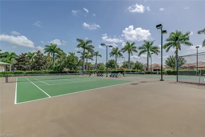 View of tennis court with community basketball court and fence