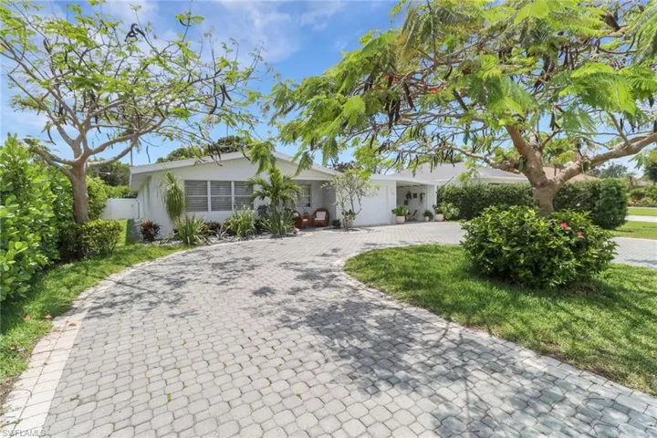 Single story home featuring decorative driveway, a garage, and stucco siding