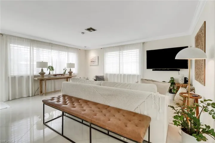 Tiled living area featuring crown molding