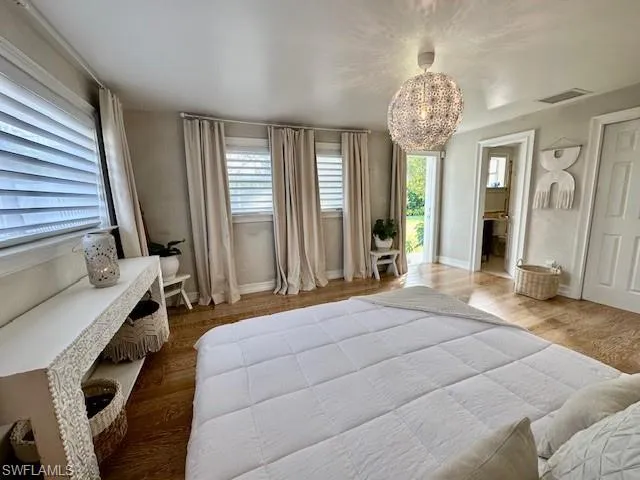Master Bedroom with room darkening curtains featuring wood finished floors