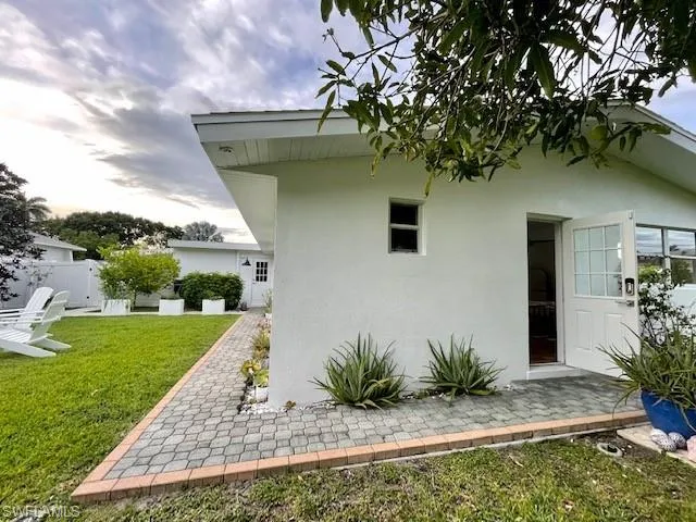 Rear view of house with walkway and tstucco siding