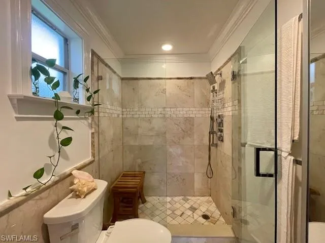 Master Bathroom with a tiled shower and ornamental molding