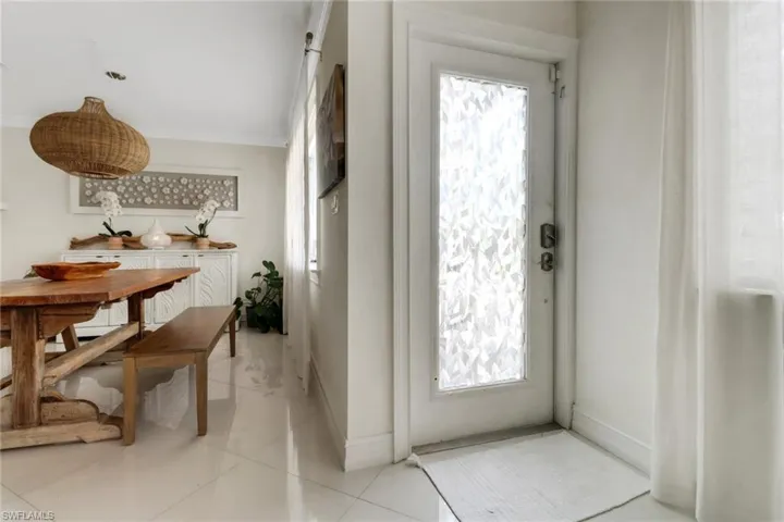 Entrance foyer featuring crown molding and light tile patterned floors