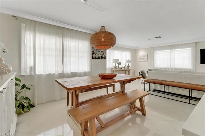 Dining room with crown molding and light tile patterned flooring